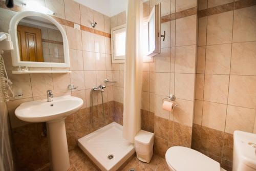 a bathroom with a sink and a shower and a toilet at Sofia Hotel in Nikiana