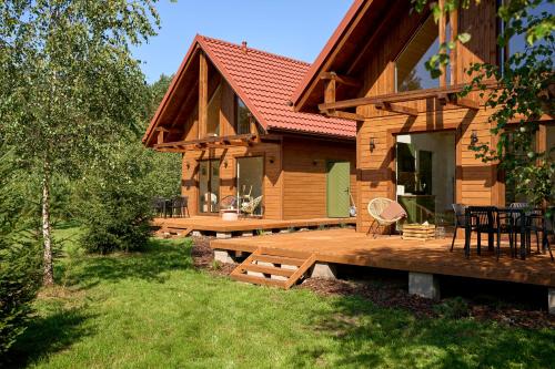 a log cabin with a deck and a patio at Osada Iwiec-Karpaty 