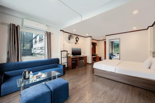 a bedroom with a bed and a blue couch at A25 Hotel - 57 Quang Trung in Hanoi
