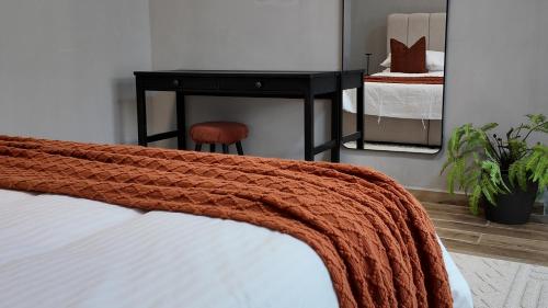a bedroom with a bed with a table and a stool at Gulfa 9 in Sinādil