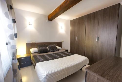 クエンカにあるEl Balcón del Salvadorの大きなベッドと木製のキャビネットを備えた寝室