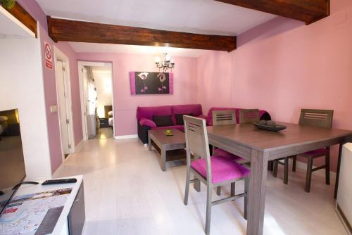 クエンカにあるEl Balcón del Salvadorの木製のテーブルとピンクの壁のあるリビングルーム
