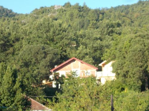 a house in the middle of a mountain at Guesthouse Feel Lake in Virpazar