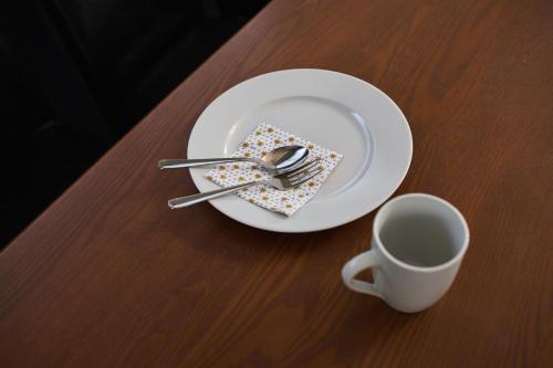 a plate with fork and spoon and a cup on a table at 成田空港から31分で駅徒歩8分富士桜侍3ldk 63平米 最大8人静か in Matsudo