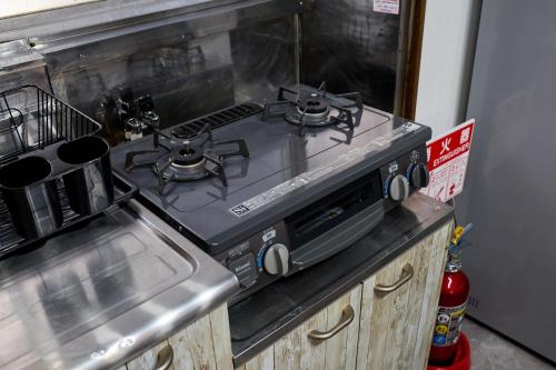 a stove top oven sitting on top of a kitchen counter at 成田空港から31分で駅徒歩8分富士桜侍3ldk 63平米 最大8人静か in Matsudo