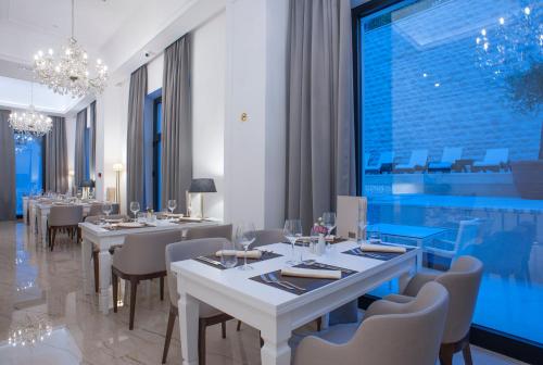 a restaurant with tables and chairs and a large window at Hotel Moskva in Budva