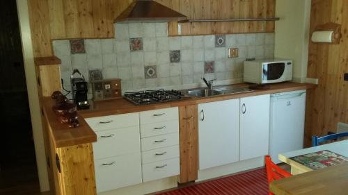 uma cozinha com armários brancos, um lavatório e um micro-ondas em Ca' Lina em Lainate
