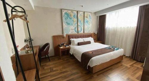 a hotel room with a large bed and a desk at James Joyce Coffetel Shenyang North Railway Station Qishan Road Metro Station in Shenyang