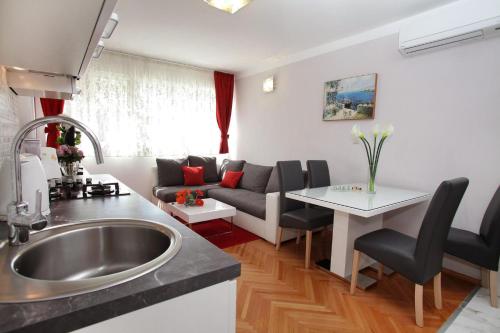 een keuken en een woonkamer met een wastafel en een bank bij Apartment Grga in Split