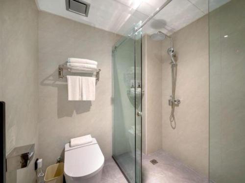 a bathroom with a glass shower and a toilet at GreenTree Inn Harbin Central Avenue in Harbin