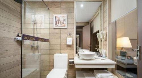 a bathroom with a toilet and a sink at Zhuhai Aqueen Hotel in Zhuhai
