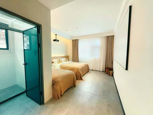 a hotel room with two beds and a sliding glass door at Shiguang Wai · Manhai Yunshe Homestay in Dali Ancient Town
