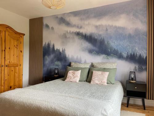 a bedroom with a bed with a painting on the wall at Gîte PREY DES VOSGES in Prey