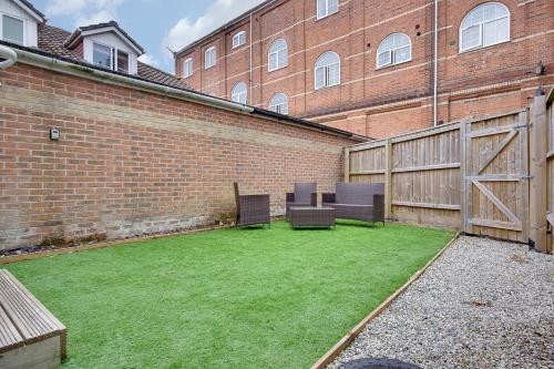 a yard with two chairs and a brick building at Palmerston Road in Bournemouth