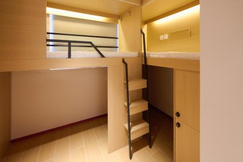 a small room with a bunk bed and a closet at Jingfengyan's Home in Beijing