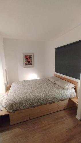 a bedroom with a bed with a wooden frame at Parking gratuit, garage vélo privatif, proche tramway in Rezé