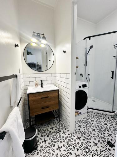 a white bathroom with a sink and a shower at Skytower views, Wi-Fi, washer & dryer!! in Auckland
