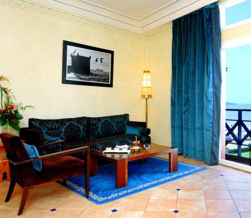 a living room with a couch and a table at Le Médina Essaouira Thalassa Sea & Spa - MGallery Collection in Essaouira