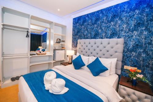 a bedroom with a large bed with blue walls at Baron Luxury Boutique in Nuwara Eliya