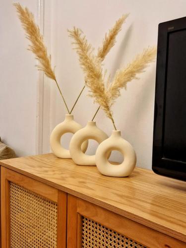three white vases sitting on top of a tv at Tranquil Condo in Zamalek in Cairo