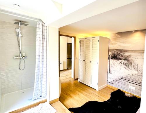 ein Badezimmer mit ebenerdiger Dusche und Badewanne in der Unterkunft Maison de vacances à 900m de la plage in Stella-Plage