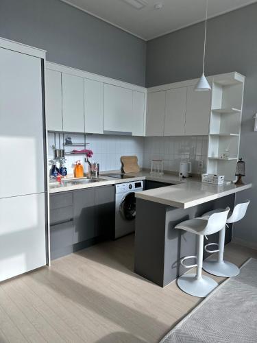 a kitchen with white cabinets and a table and chairs at Buldang Hot Place in Ch'ŏnan-yŏk