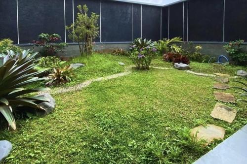 a garden with a lawn and some plants at The Villa Nirvana Tawangmangu in Tawangmangu