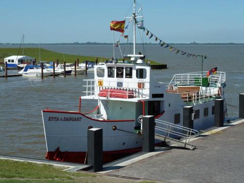 un bateau est amarré à un quai dans l'eau dans l'établissement Dirks Ferienhaus Arngast, à Dangast