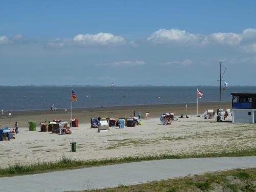 une plage avec beaucoup de monde et l'océan dans l'établissement Dirks Ferienhaus Arngast, à Dangast