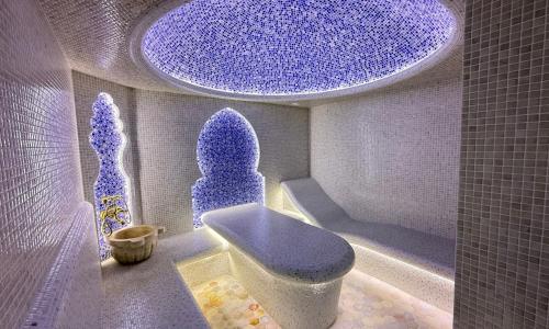 Un baño con inodoro azul y techo azul. en Mubina East Hotel, en Bukhara
