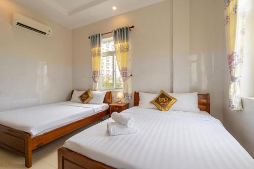 a bedroom with two beds and a window at IU Beach Hotel Phú Quốc in Phu Quoc