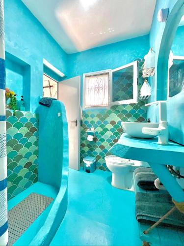a blue bathroom with a sink and a toilet at Beach house MAREA CORAL in Melilla