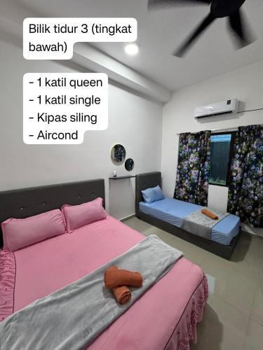 a bedroom with two beds with pink and gray sheets at AzureGreen at AmanPlus Kuantan in Kuantan