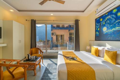a bedroom with a large bed and a balcony at The Social Stays Rishikesh formerly ArtBuzz in Rishīkesh