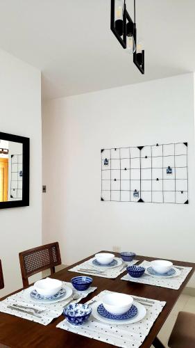 a dining room table with blue and white dishes on it at 2 Bedrooms, 2 Bathrooms, AC, WiFi, Pool, GYM, No Blackouts, Santiago in Hato Mayor