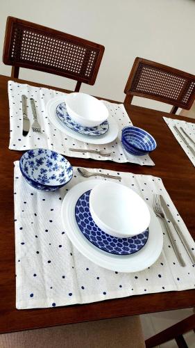 a table with blue and white plates and utensils at 2 Bedrooms, 2 Bathrooms, AC, WiFi, Pool, GYM, No Blackouts, Santiago in Hato Mayor
