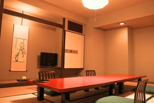 a conference room with a red table and a tv at Bansuirou Fukuzumi 萬翠楼 福住 in Hakone