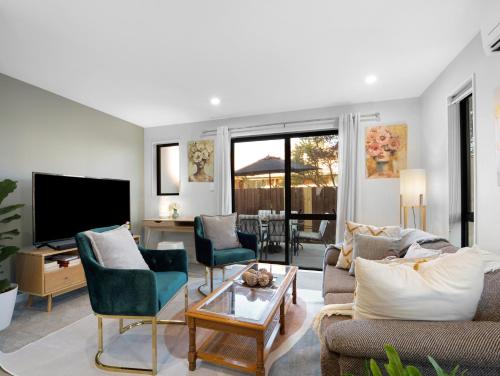 a living room with a couch and chairs and a television at Apartment on Short ! in Christchurch