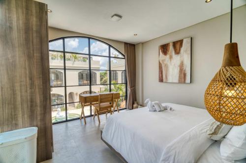 a bedroom with a bed and a large window at Coco Lifestyle Residence in Canggu