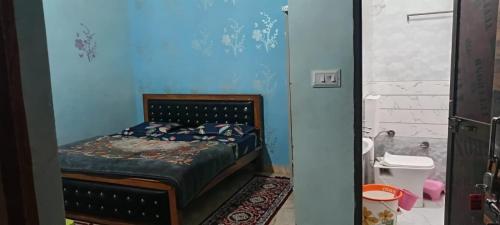 a bedroom with a bed in a blue room at Shri Ram Lala Palace in Jāmb