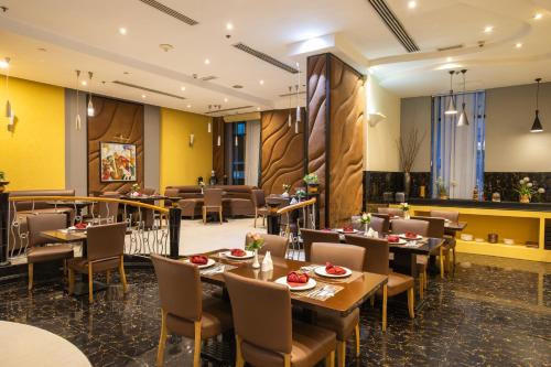 a restaurant with tables and chairs in a room at THE PARK HOTEL Formerly Al Jawhara Gardens in Dubai