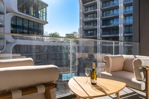 a balcony with a table and a bottle of wine at Mercury Suite Designer Apartment with Pool Access in St Julian's