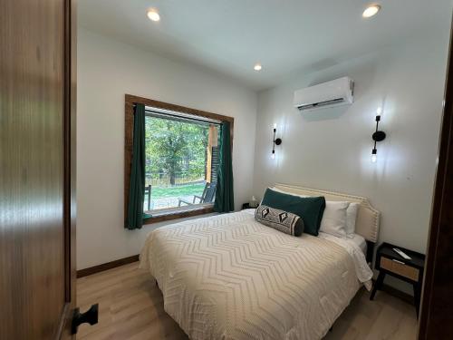 The Cabins at Northwoods Trails في هوت سبرنغز: غرفة نوم بها سرير ونافذة
