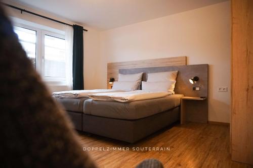 a bedroom with a bed with a wooden headboard at Hotel verWeiler in Fischen