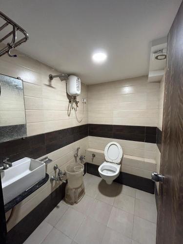 a bathroom with a toilet and a sink at Hotel Pathik in Ahmedabad