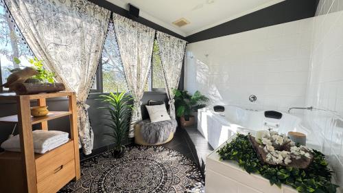 a bathroom with a tub and a toilet and a window at Couple's Luxury Resort Spa Retreat in Cowes