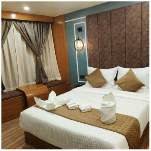 a hotel room with a bed with white towels on it at The House Hotel Darjeeling in Darjeeling
