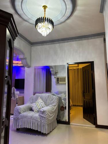 a room with a chandelier and a chair in a room at Spacious Home with Great Location in Panabo City in Panabo