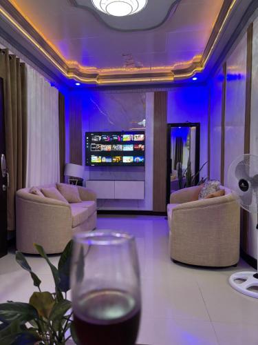 a living room with couches and a glass of wine at Spacious Home with Great Location in Panabo City in Panabo
