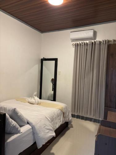 a bedroom with a large bed and a mirror at Spacious Home with Great Location in Panabo City in Panabo